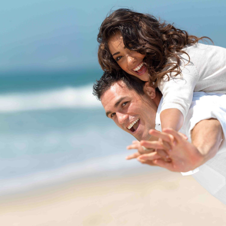 couple smiling and hugging at the beach