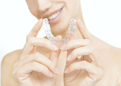 girl holding invisalign braces